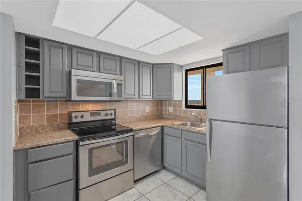 a kitchen with white cabinets and white appliances
