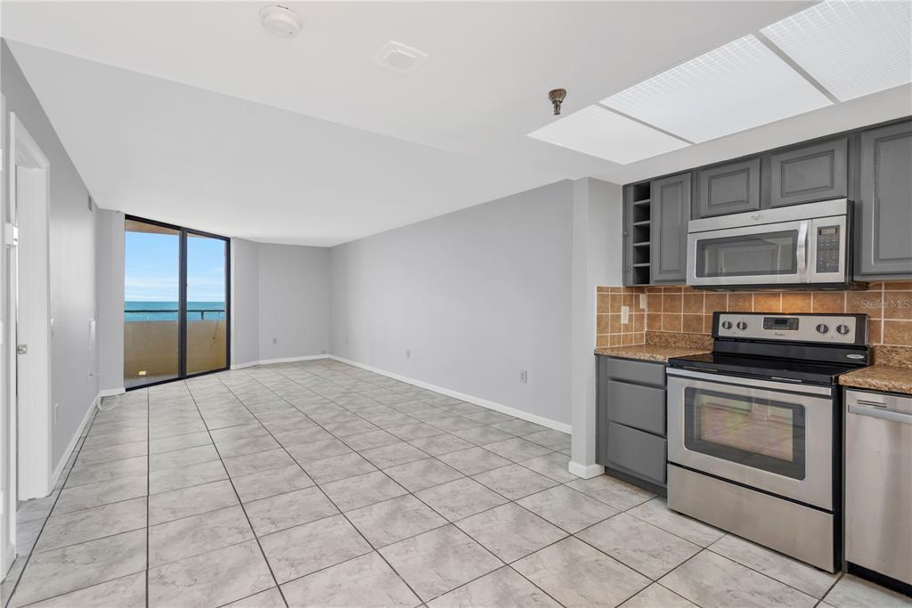 6009 Sea Ranch Drive, Unit 705 Hudson, FL 34667 - Photo 6 of 43 a kitchen with stainless steel appliances granite countertop a stove a microwave and a refrigerator