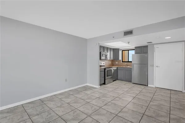 a view of a kitchen with refrigerator and windows