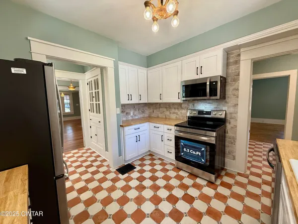 a kitchen with stainless steel appliances a sink and a refrigerator