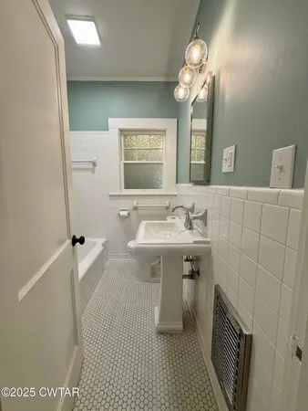 a bathroom with a sink a toilet a mirror and shower