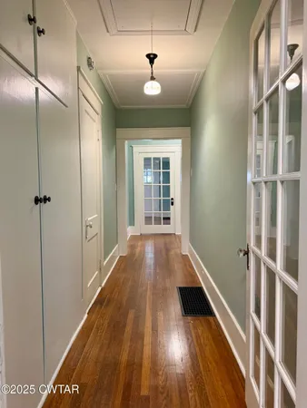 a view of a hallway with wooden floor and staircase