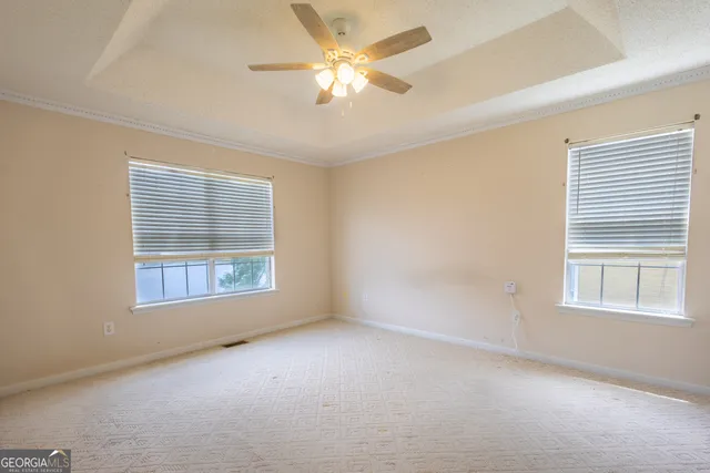 an empty room with a window and a fan