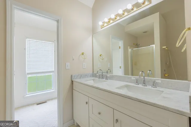 a bathroom with a granite countertop sink and a mirror