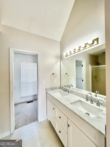 a spacious bathroom with a granite countertop sink mirror and shower