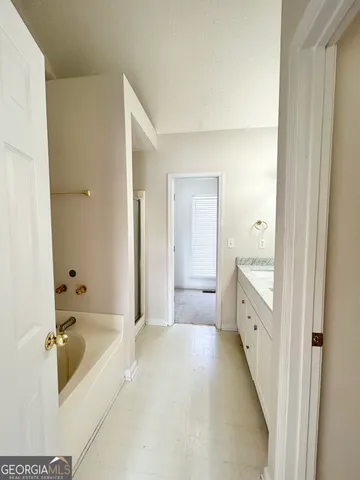 a bathroom with a tub sink and mirror