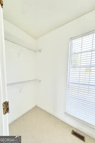 a view of a room with a white wall and a window