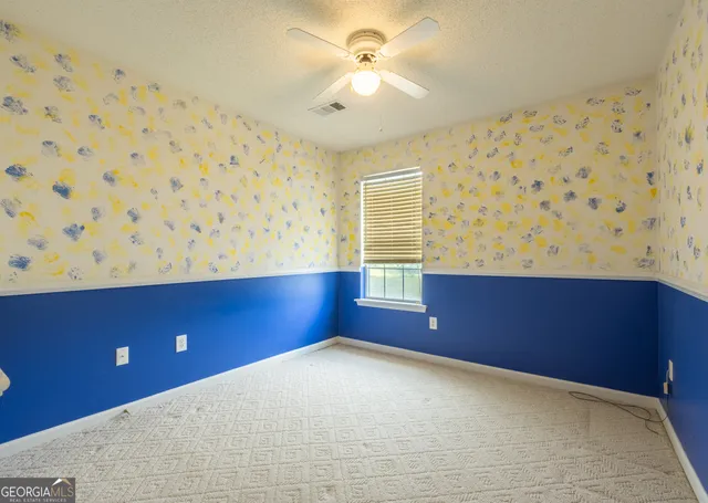 an empty room with closet and a chandelier fan