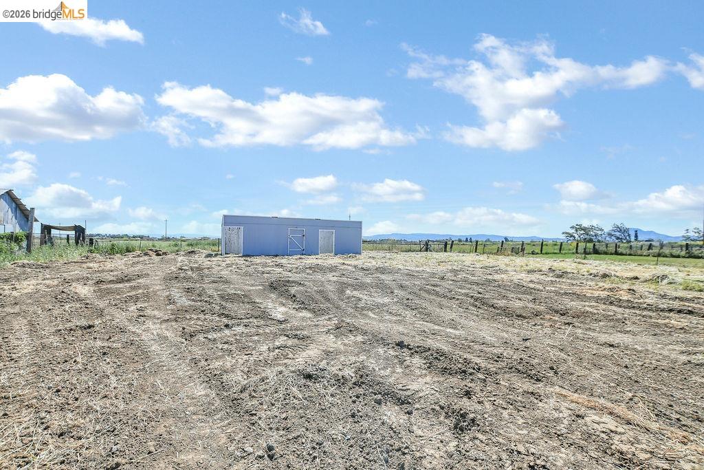2191 East Cypress Road Oakley, CA 94561 - Photo 35 of 48 View of yard featuring an outdoor structure, a view of countryside, an outbuilding, and a mountain view