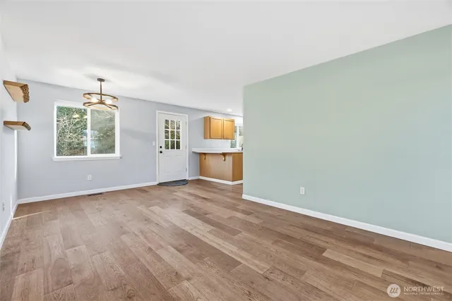 an empty room with windows and cabinet
