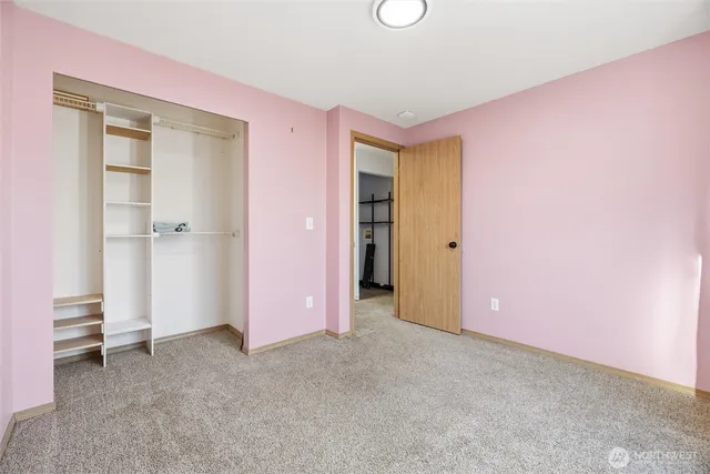 an empty room with closet and a window
