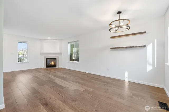 an empty room with windows and fireplace