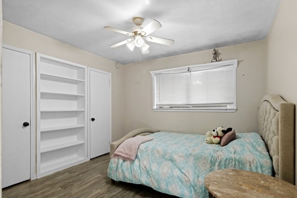 9702 Tiltree Street Houston, TX 77075 - Photo 12 of 24 a bedroom with a bed and wooden floor