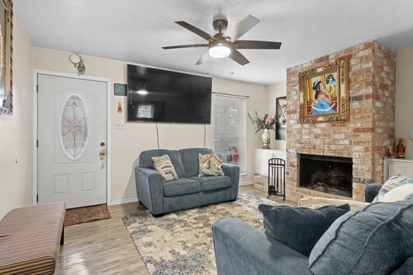 9702 Tiltree Street Houston, TX 77075 - Photo 3 of 24 a living room with furniture a flat screen tv and a fireplace