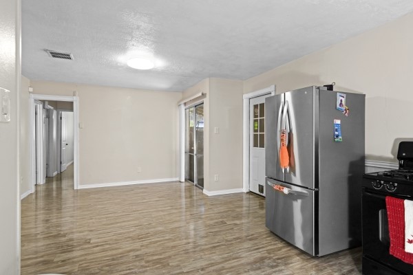 9702 Tiltree Street Houston, TX 77075 - Photo 8 of 24 a view of a kitchen with refrigerator and wooden floor