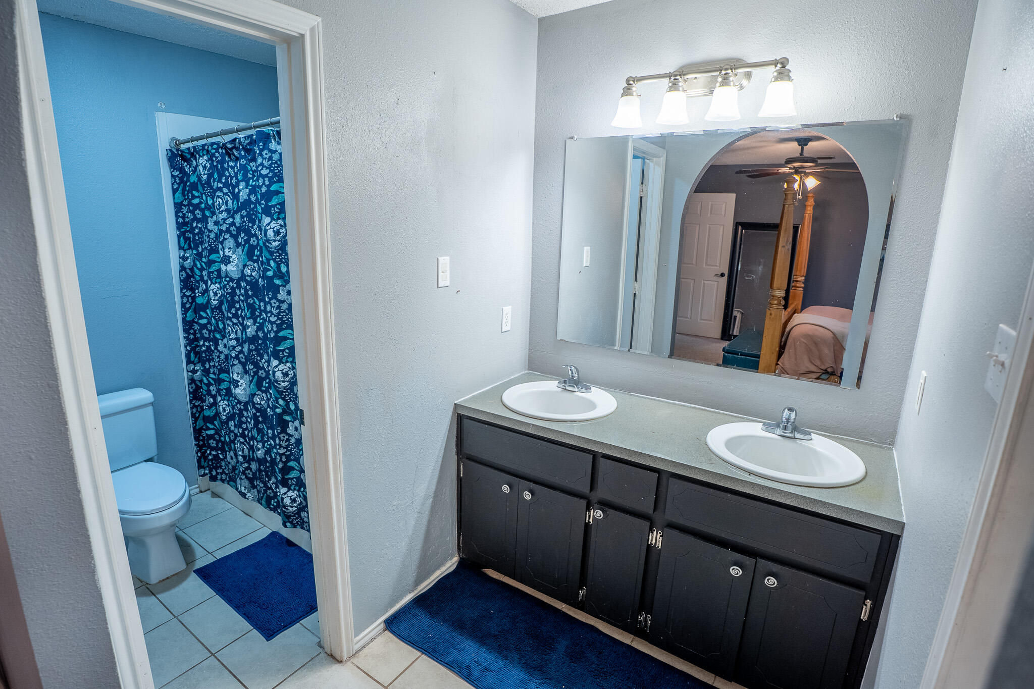 1609 78th Street Lubbock, TX 79423 - Photo 17 of 36 a bathroom with a sink a toilet and a mirror