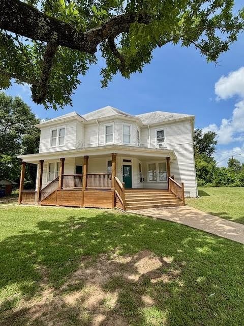 1403 14th Street, Unit 3 Huntsville, TX 77340 - Photo 1 of 9 a front view of a house with a yard table and chairs