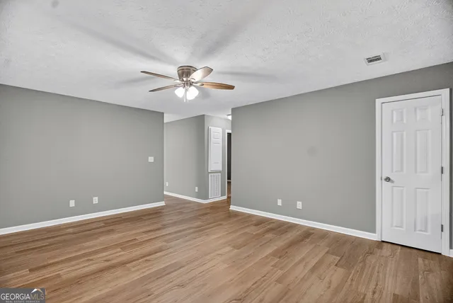 a view of an empty room with wooden floor