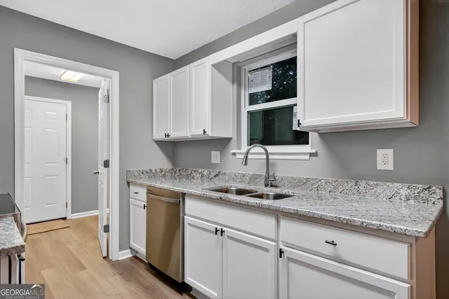 a kitchen with granite countertop a sink and cabinets
