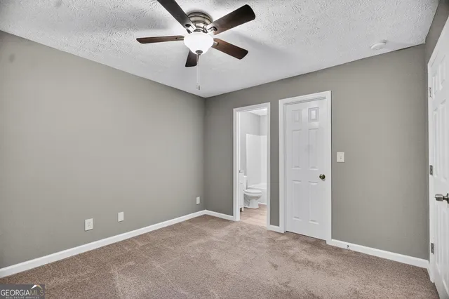 an empty room with a ceiling fan and a fan