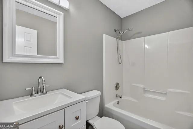 a bathroom with a sink toilet vanity and shower