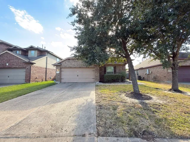 a view of a house with a yard and large tree