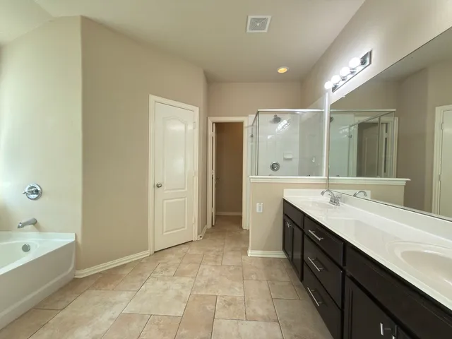 a spacious bathroom with a bathtub sink and mirror