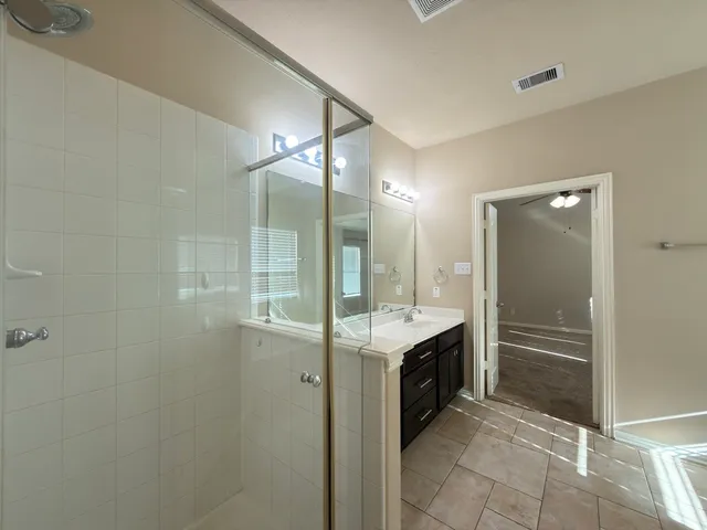 a bathroom with a granite countertop sink mirror and shower