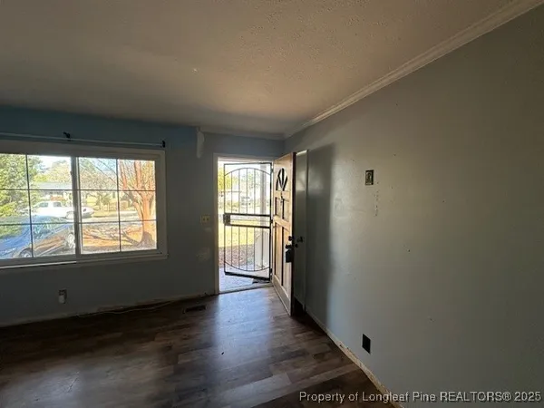 an empty room with wooden floor and windows