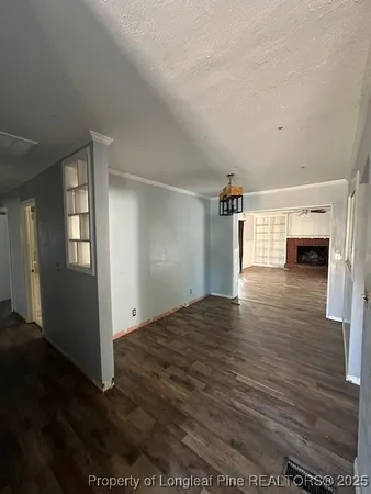 a view of empty room with wooden floor