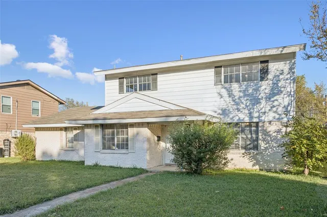 a front view of a house with a garden and yard