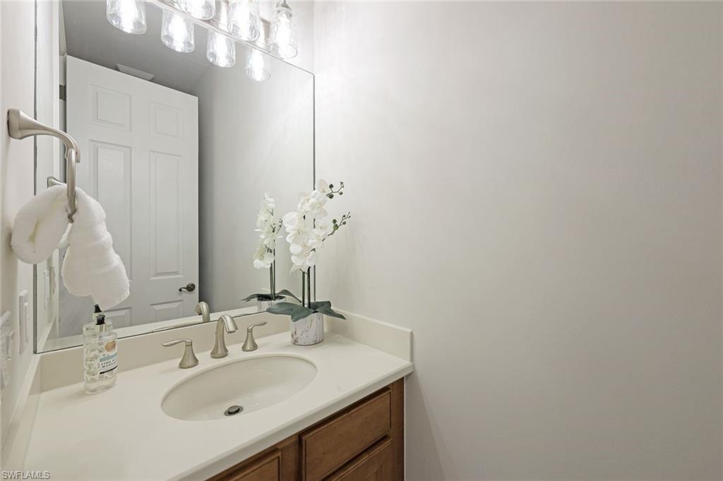 1423 Santiago Circle, Unit 1702 Naples, FL 34113 - Photo 13 of 46 a bathroom with a sink vanity and a mirror