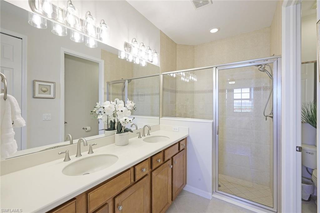 1423 Santiago Circle, Unit 1702 Naples, FL 34113 - Photo 15 of 46 a bathroom with a sink double vanity and shower