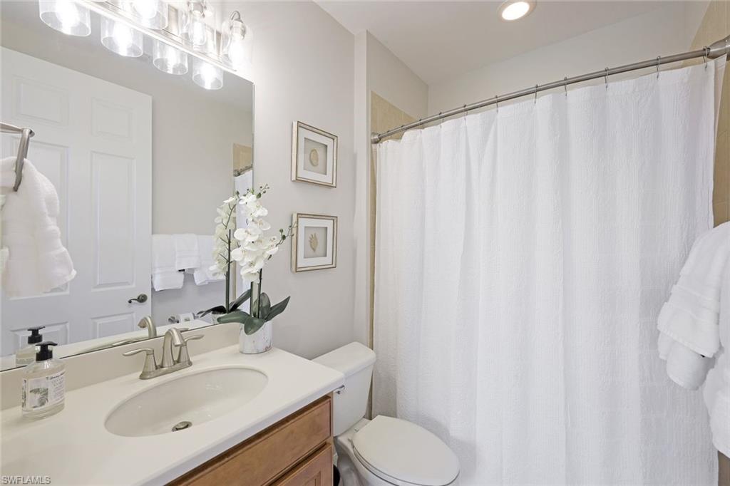 1423 Santiago Circle, Unit 1702 Naples, FL 34113 - Photo 17 of 46 a bathroom with a sink vanity mirror and toilet
