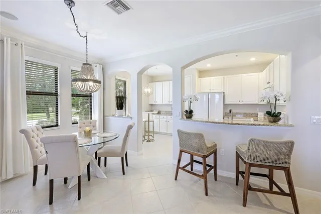 a dining room with furniture a chandelier and window