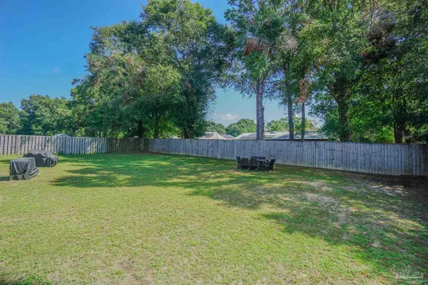 a view of a yard with a fence and trees