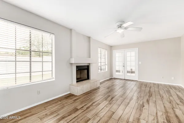 a view of empty room with wooden floor and fan