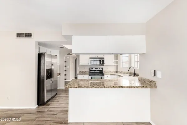 a kitchen with stainless steel appliances granite countertop a refrigerator and a sink