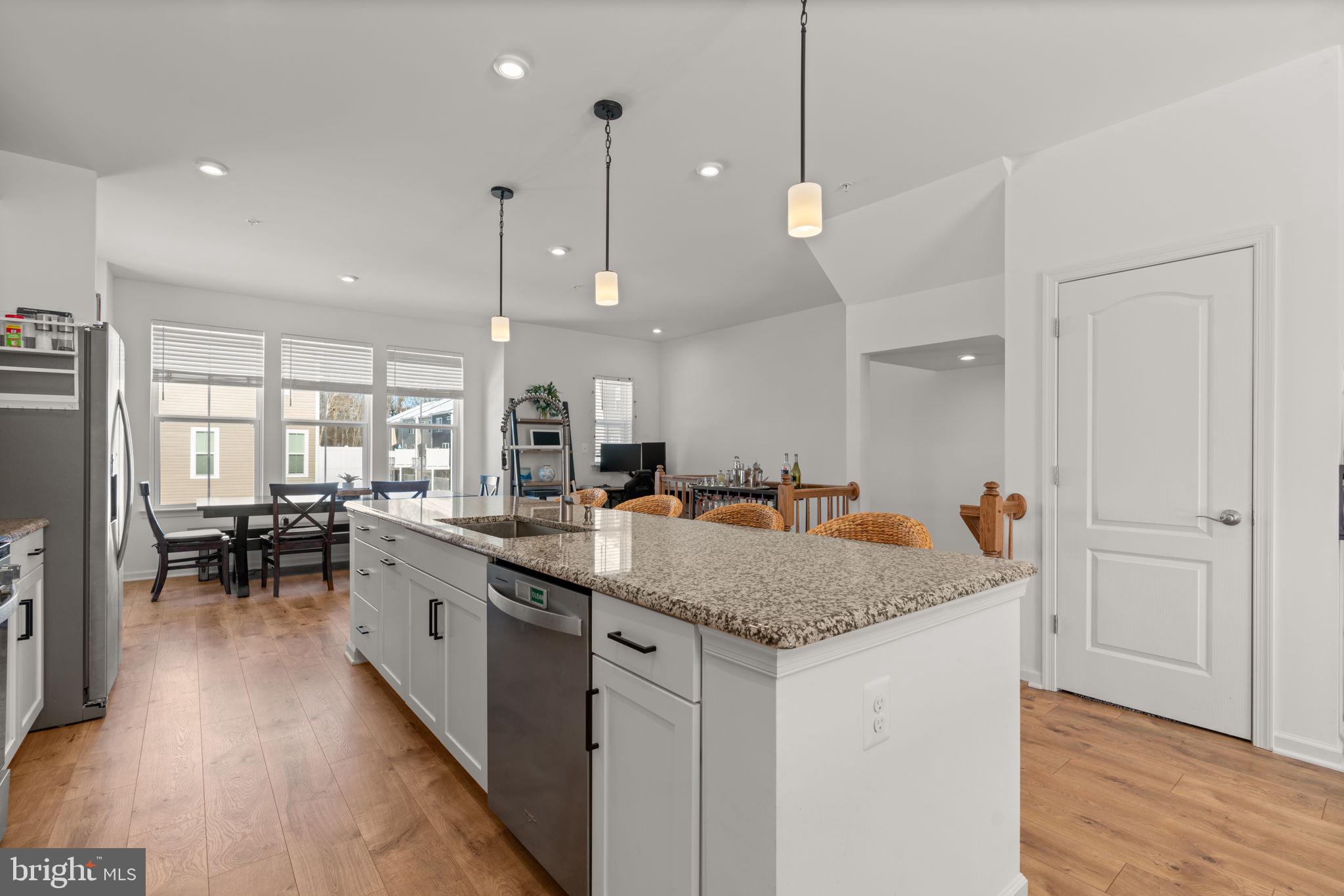 1605 Aster Lane Hanover, MD 21076 - Photo 11 of 44 a kitchen with center island a sink stainless steel appliances and wooden floor