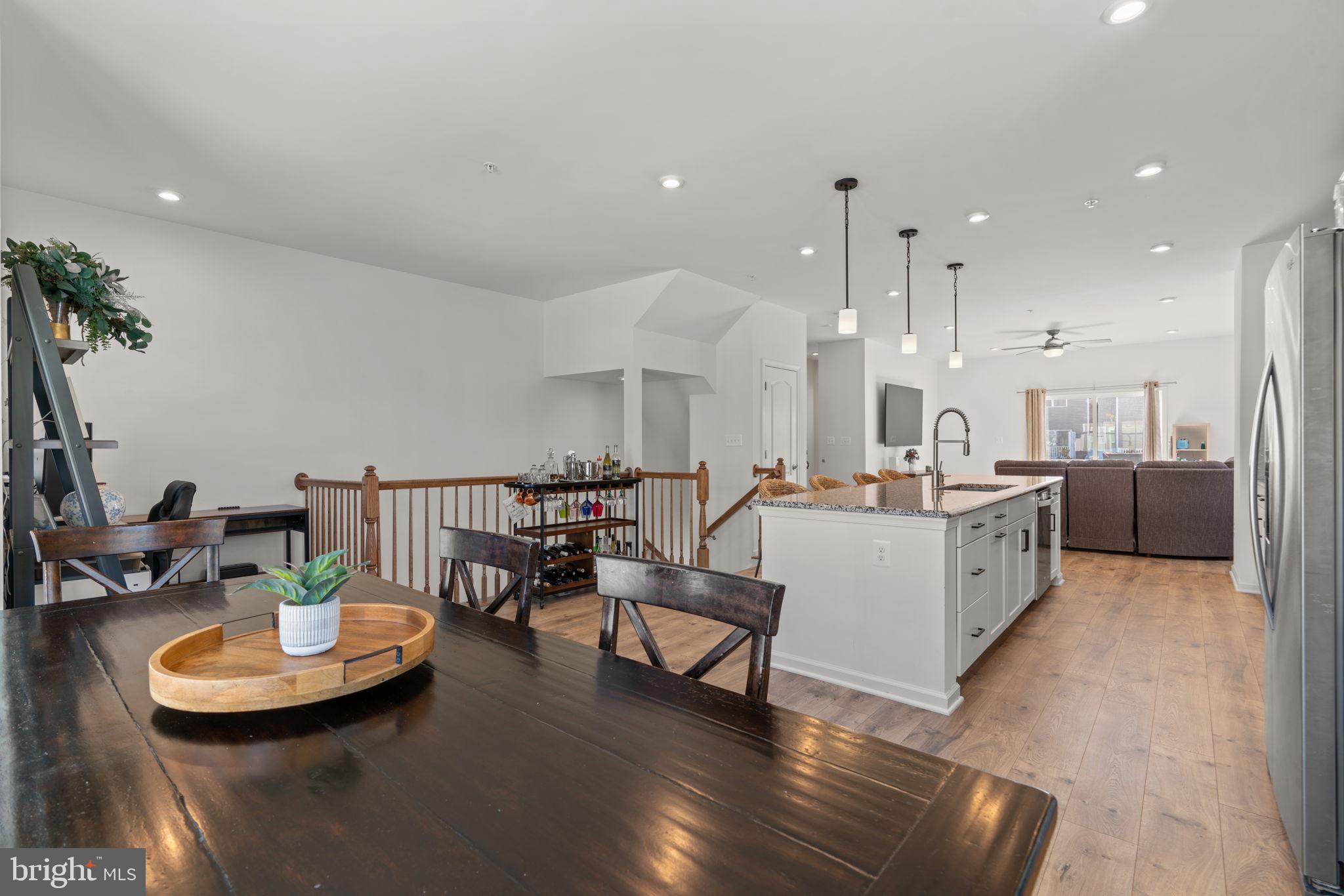 1605 Aster Lane Hanover, MD 21076 - Photo 18 of 44 a kitchen with stainless steel appliances kitchen island granite countertop a table chairs and a living room view