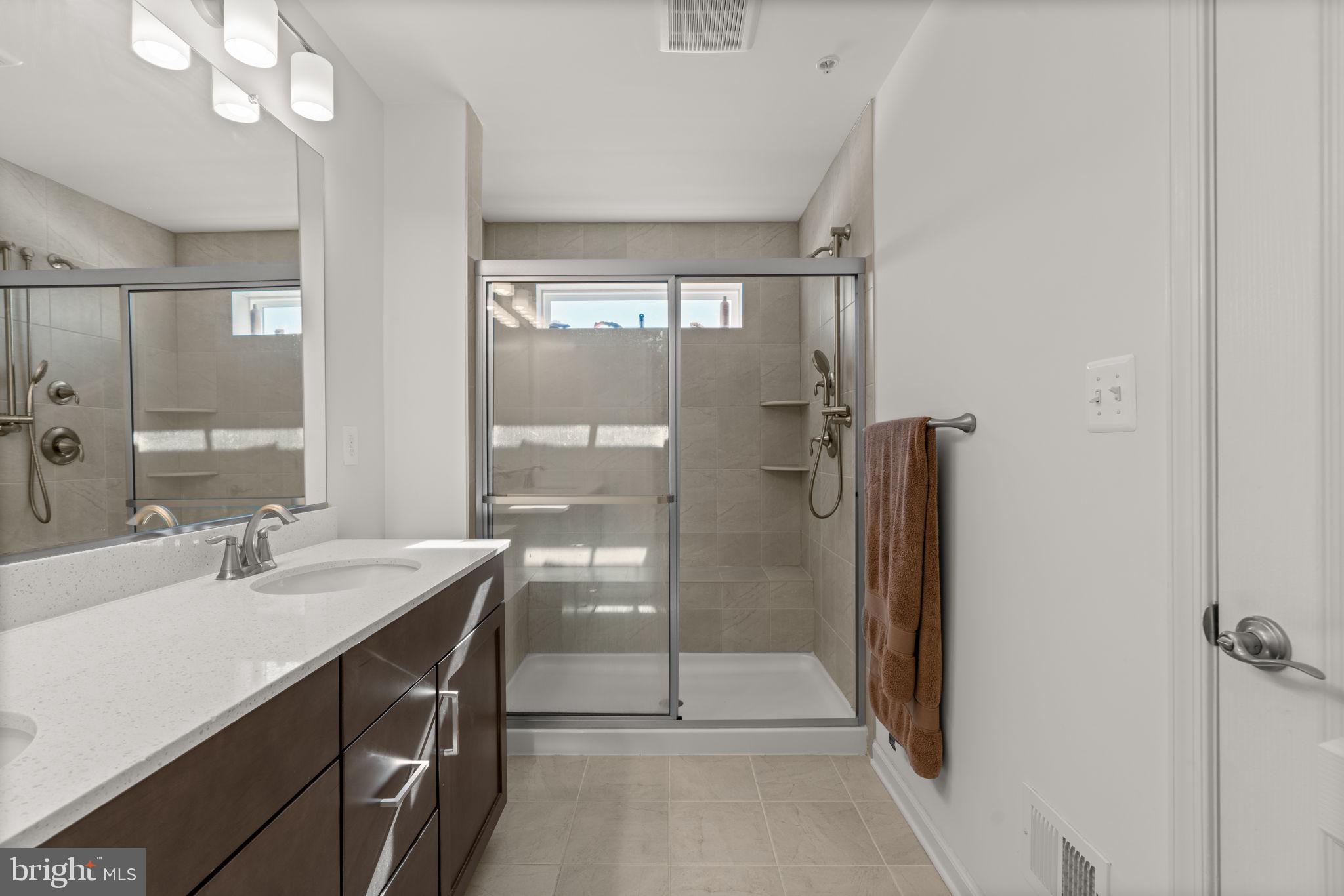 1605 Aster Lane Hanover, MD 21076 - Photo 25 of 44 a bathroom with a double vanity sink a toilet a mirror and shower