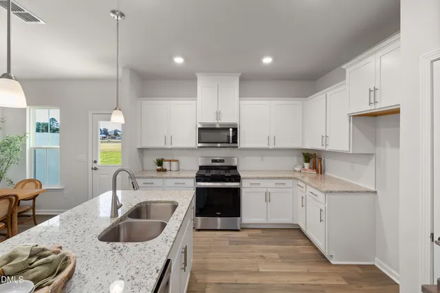 a kitchen with stainless steel appliances granite countertop a sink stove and refrigerator