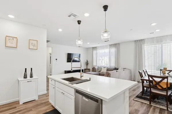 a kitchen with a table chairs sink and cabinets