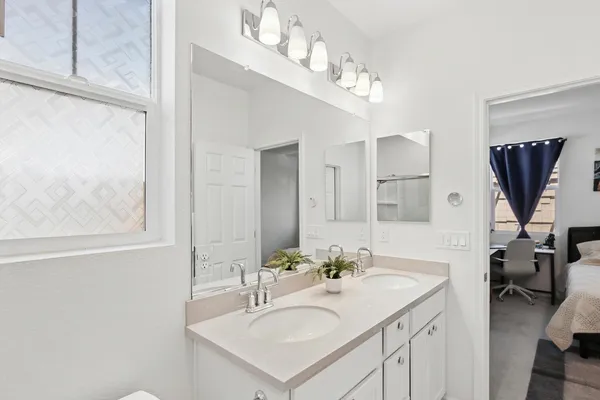a en suite bathroom with a sink double vanity and a mirror