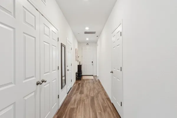 a view of a hallway with wooden floor and a hallway