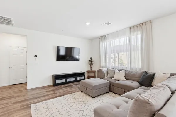 a living room with furniture wooden floor and a flat screen tv