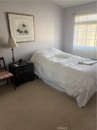 a bed sitting in a bedroom next to a window