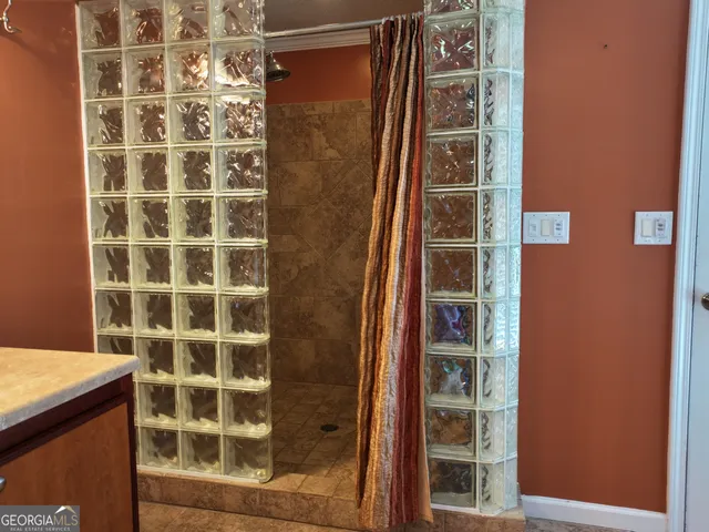 a bathroom with a shower and a glass door