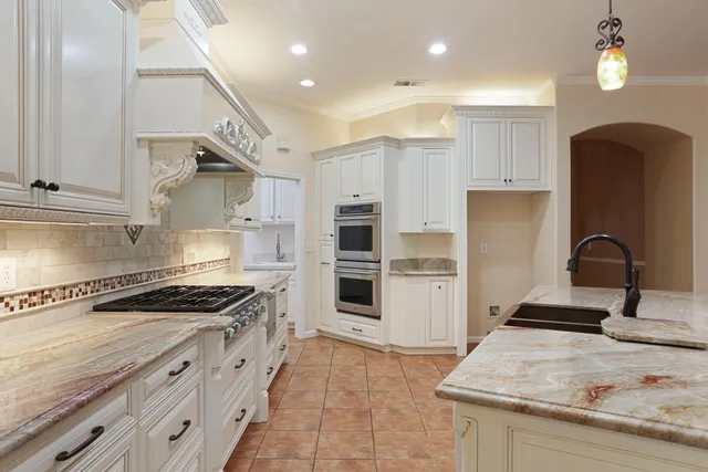 a kitchen with granite countertop a sink stove and cabinets