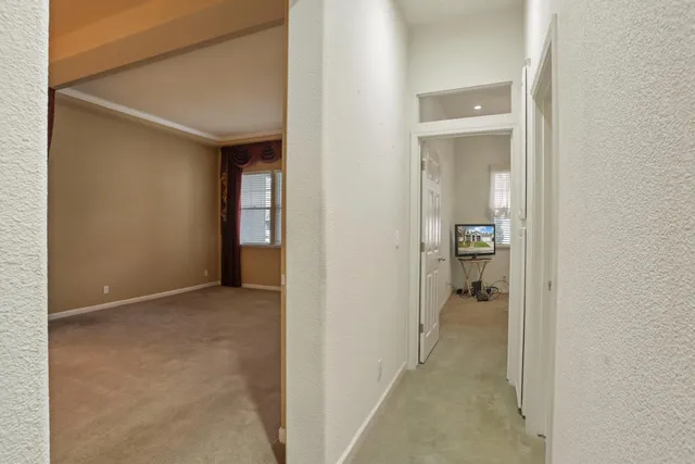 a bedroom with a bed a dresser and windows